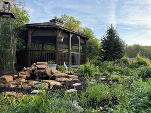 [Gazebo] A fully screened-in gazebo and waterfall pond, perfect for morning chats or late-night laughs, this is the spot to take it all in.