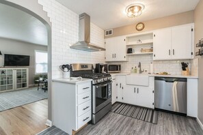 Stainless appliances, quartz counters and subway tiled backsplash.