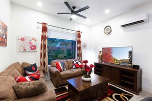 Cozy Living Room has a queen size sleeper couch, a loveseat and a 65’’ smart TV.