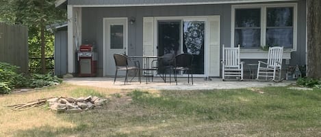 Front of cottage (water side) has patio, table, fire pit and rocking chairs