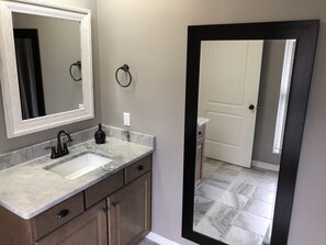 Renovated bath with wood cabinets and granite