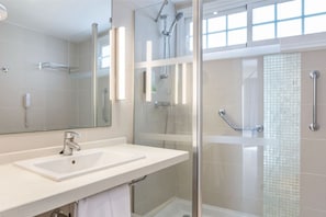 Modern and well-lit bathroom with a walk-in shower, designed for a refreshing and rejuvenating experience.