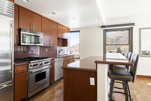 Red granite countertops in the kitchen with stainless steel appliances and chef's gas range