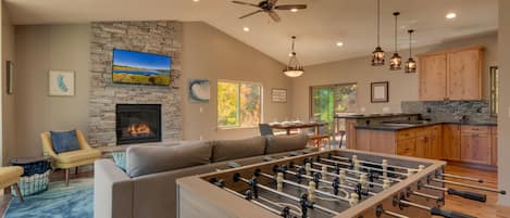 Living area with contemporary furniture, flat screen tv, fireplace, and foosball