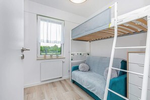  A unique bedroom with a bunk-style loft bed, making efficient use of space. The color scheme is fresh, with teal accents adding a lively touch.