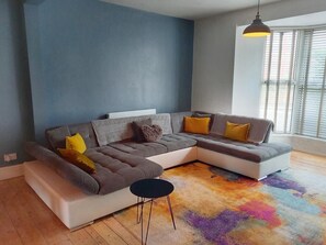 Open plan living room. The sofa doubles as a large sofa bed.