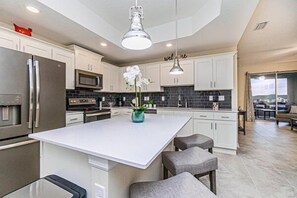 Kitchen with Island and 3 Barstools. Stainless Steel appliances and stocked with all the items needed to have a simple on the go breakfast to preparing the perfect Holiday meal.