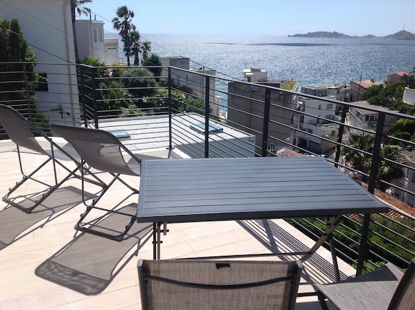 Chaises longues et table  sur la terrasse 