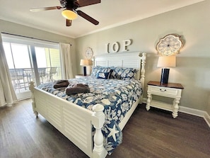 Master bedroom with king-size bed,  ceiling fan, and balcony access.