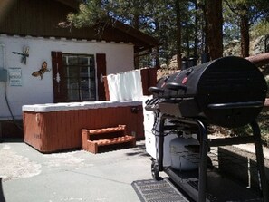 Hot tub on patio with propane grill and gas firepit