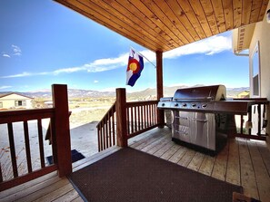 Covered deck provides sheltered entry, stunning view & stainless 4 burner grill