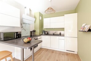 Cuisine ouverte équipée : lave-vaisselle, plaques cuisson, fours, frigo-congel