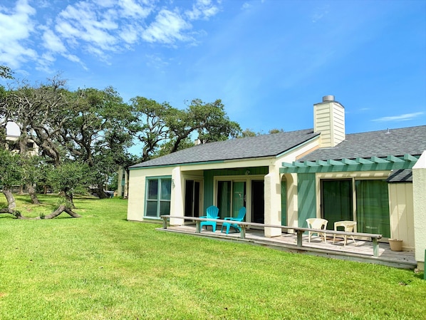 Single story townhouse nestled in rolling lawns and oak trees with bay view