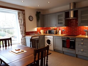 Fully equipped kitchen and dining area looking out to the garden.