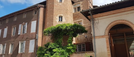 La maison, sa tour d'escalier et la petite terrasse donnant sur la place