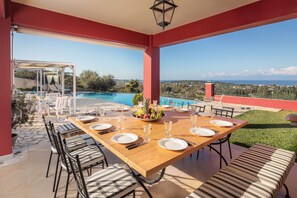 The main outdoor dining area, outside the kitchen with view of the sea and pool