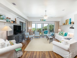 Weston Beach Place Living room with sleeper sofa, TV and access to the porch