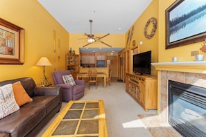 The living area features a gas fireplace, flat screen TV, and spectacular views.