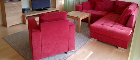 Wohnbereich mit Sofaecke, Sessel und TV