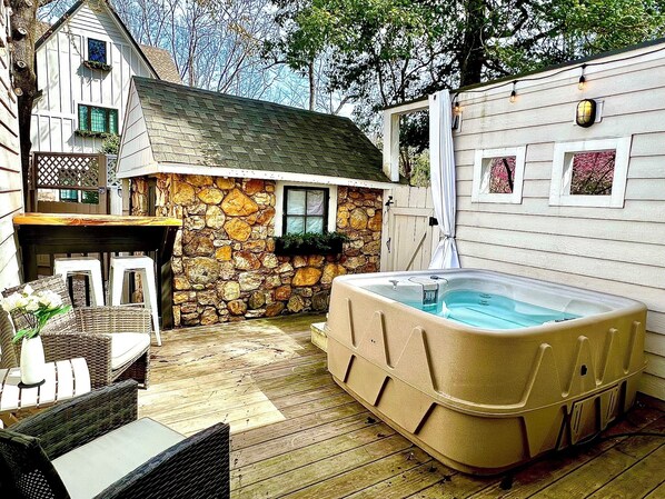Spa deck with spa towels, privacy curtain, personal bar and seating, and 4 person spa.