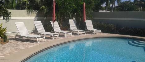 Private tropical pool with lounge chairs