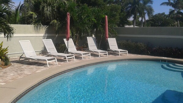 Private tropical pool with lounge chairs