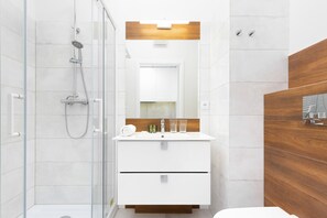 Bright bathroom with grey tiles and wood-effect tiles.