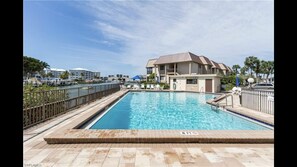 The heated community pool is situated on the bay & only steps from the condo.