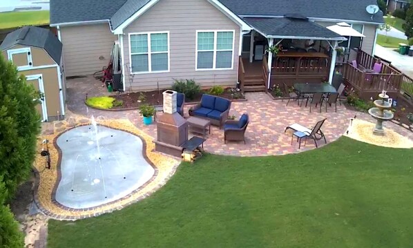 Back yard has seating for 16 and a recently added splash pad by the fireplace