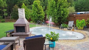 Relax by the fireplace while the children enjoy the splash pad.