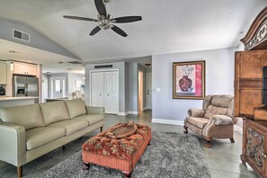 The living area features tasteful decor and vaulted ceilings.