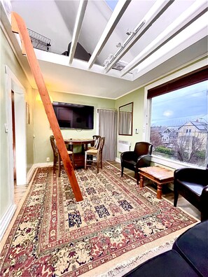 Living room with 65” TV.  Table Leaf and additional stools in closet to seat 6.