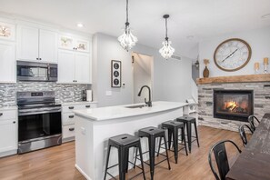 Well stocked Kitchen with quartz countertops large island glass tile backsplash
