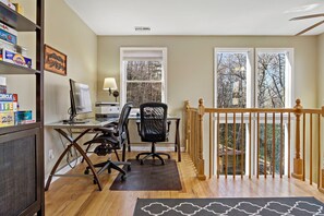 Impressive dedicated work area in the upstairs loft equipped with a fully-stocked desk, Herman Miller Aeron ergonomic chair, and printer.