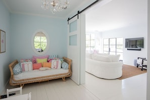 Playroom with twin daybed and cable TV. Barn doors shut for privacy.