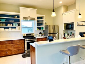 Open kitchen equipped with dinnerware, small appliances, and dishwasher.