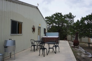 The hot tub and outdoor seating area are located on the side of the home.