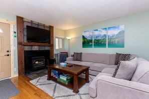 The living area features comfortable seating and a mounted flat screen TV.