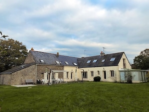 Façade arrière de la maison avec grande terrasse exposée sud et jardin clos