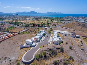 View of the house from above showing the nearby beach and mountains.