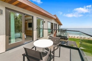 Private outdoor balcony with dining chairs and table.