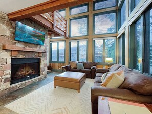 Open living room with a fireplace and incredible floor to ceiling windows!