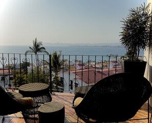 Covered balcony off the bedroom has an expansive view of the bay.