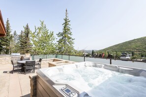 Private hot tub and seating area on patio on a beautiful summer day