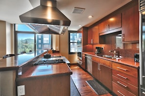 Warm tones in the kitchen with cherry wood cabinets and hardwood floors and red granite countertops