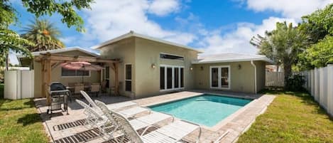 Beautiful backyard with pool and lounge chairs.