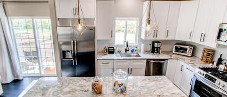 Spacious Kitchen with natural Quartzite countertops and new SS appliances.