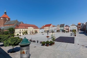 A scenic view of a town square with a fountain and historic buildings in the background.