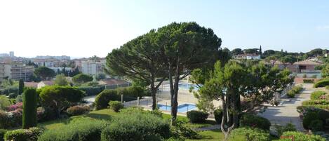 Vue du balcon sur la piscine et le jardin