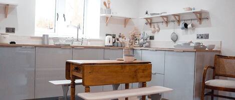 Kitchen area with seating for 4, hanging utensils